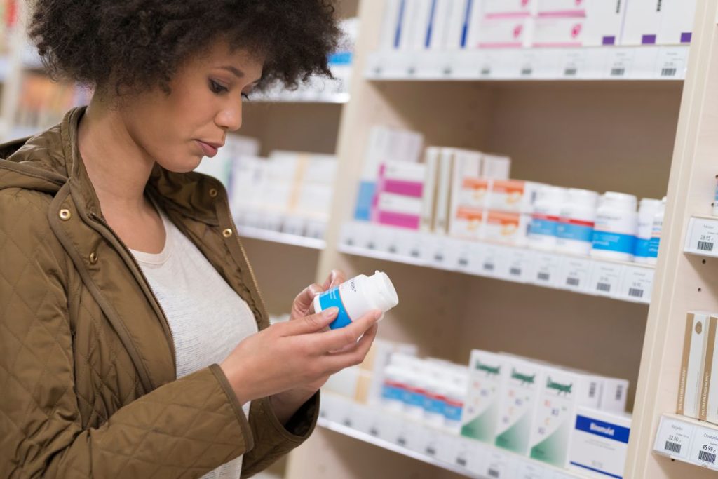 A lady checking FDA approval on a drug bottle.