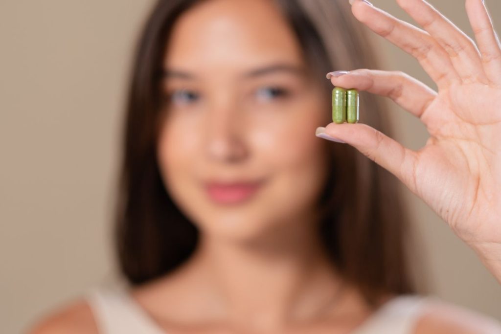 A lady showing her daily dose of kava capsules