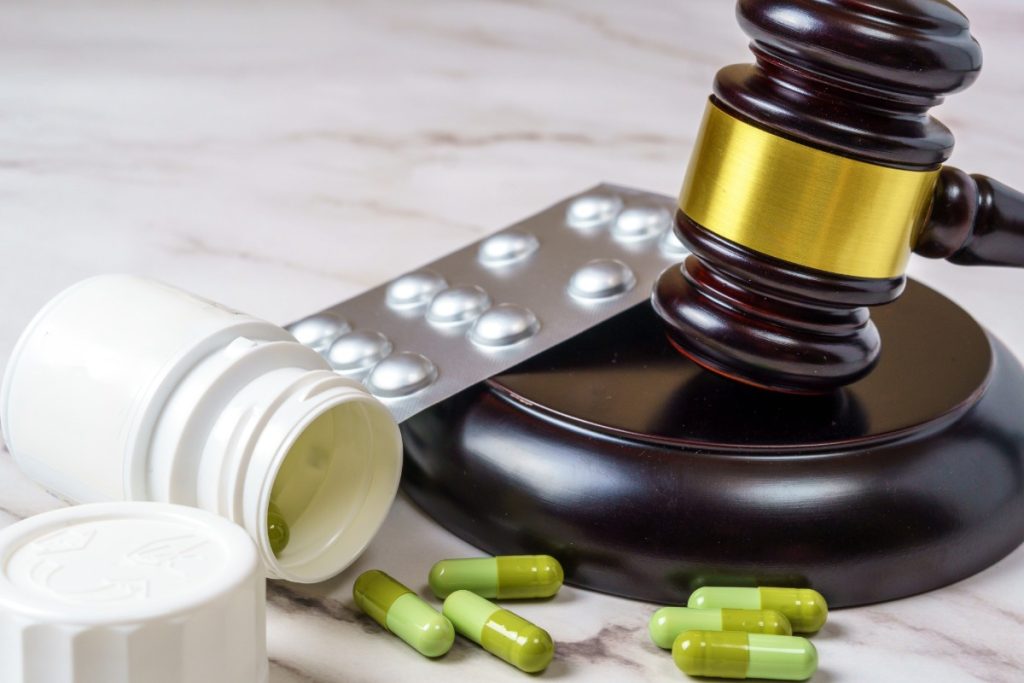 An image depicting a legal gavel alongside Kanna capsules and tablets